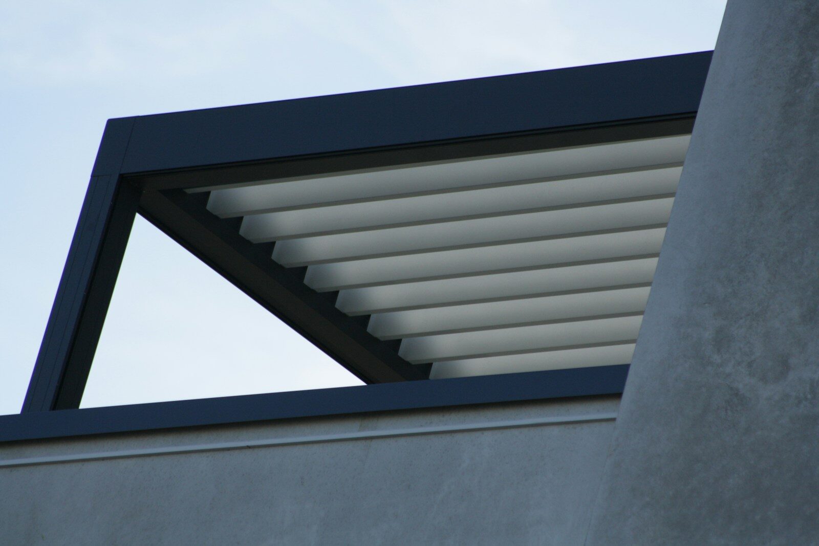 Modern pergola with adjustable louvers against sky