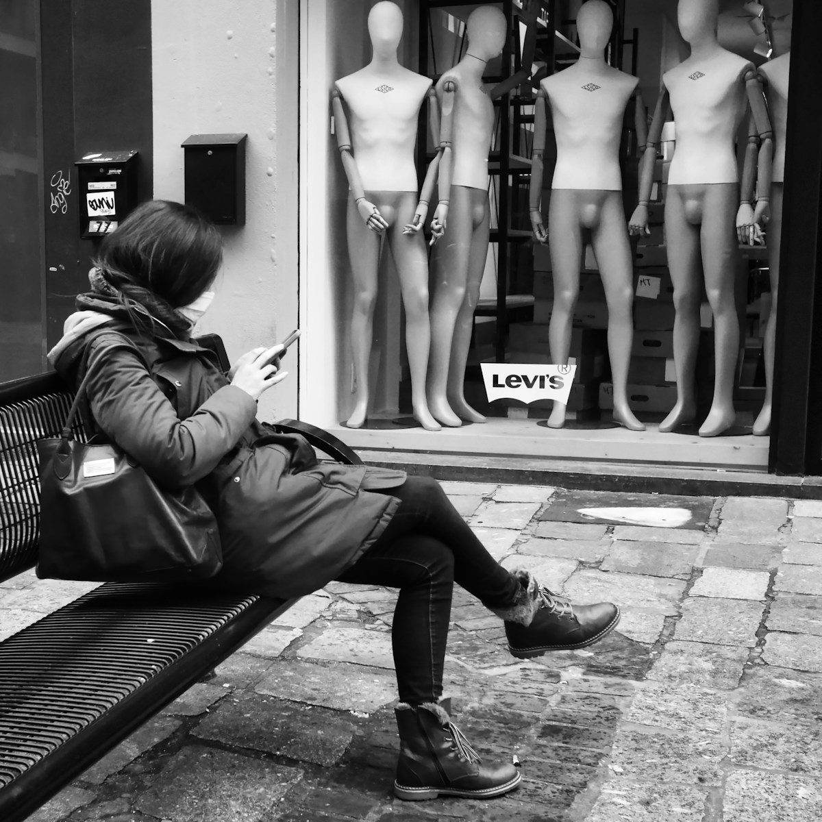 grayscale photo of woman in black bikini sitting on bench